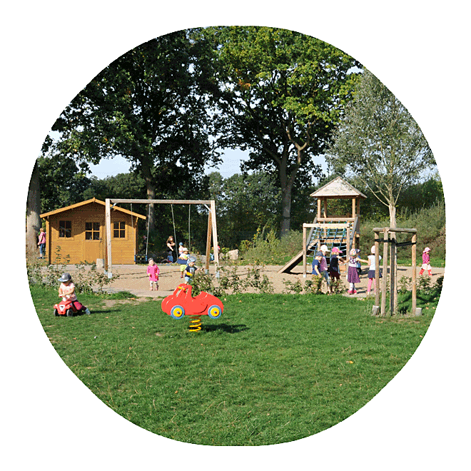 Das Außengelände der Kita Wiesenpark mit vielen spielenden Kindern bei schönem Wetter.